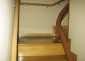 階段昇降機　屋内曲線型　曲線部分でもレールと歩行者部分が余裕あり